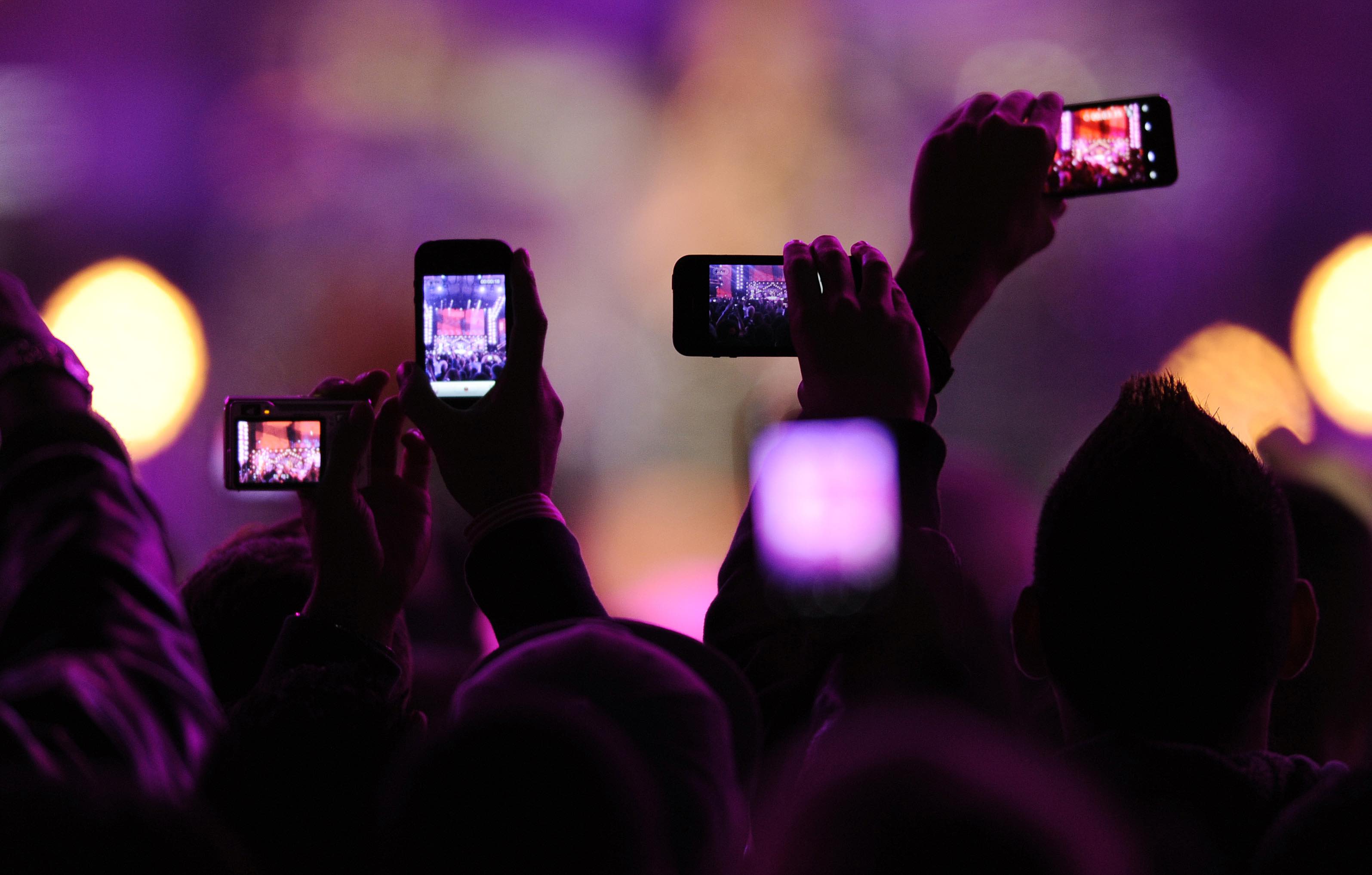 Fans take photos with their mobile phones during the VH1 "Divas Salute The Troops" show at the Marine Corps Air Station Miramar in San Diego, December 3, 2010. REUTERS/K.C. Alfred (UNITED STATES - Tags: ENTERTAINMENT SCI TECH IMAGES OF THE DAY) - RTXVDL9